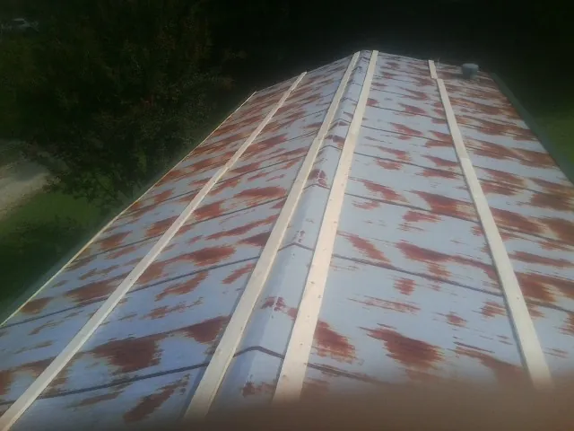 Rusted metal roof panels with new wood purlins before replacement — Storm Damage Roof Repair in Glencoe by Roofing Brothers
